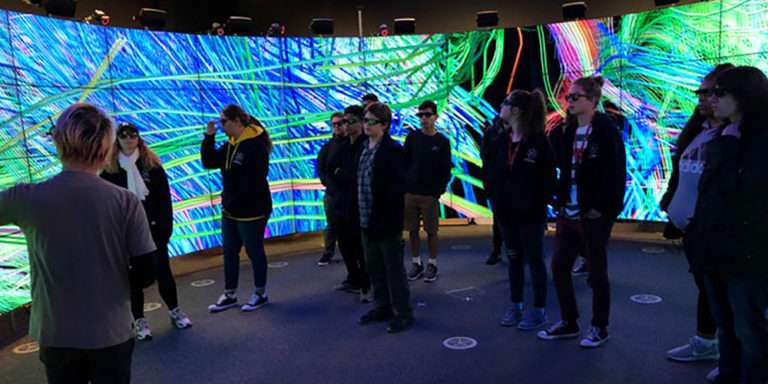 Indigenous students stand inside a human brain simulation