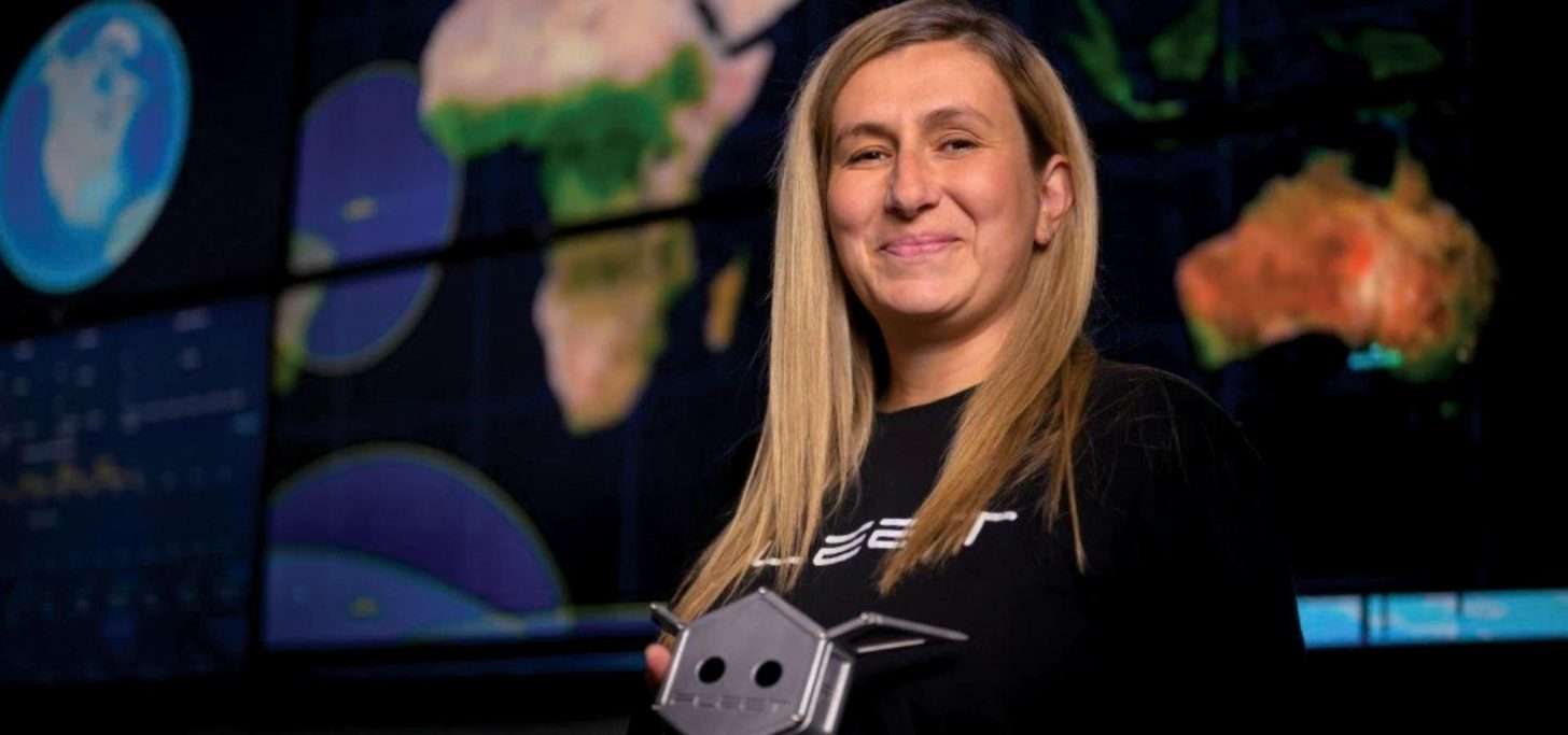 Woman with long blonde hair in front of science images