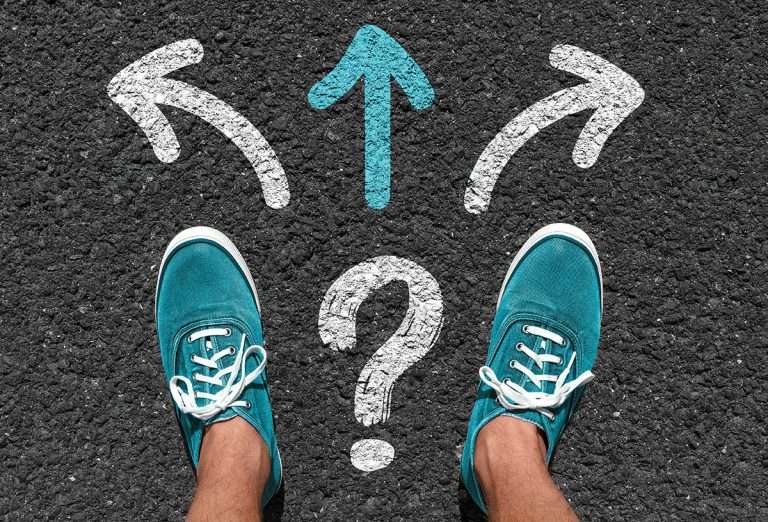 Arrows on asphalt with blue shoes wondering which way to go