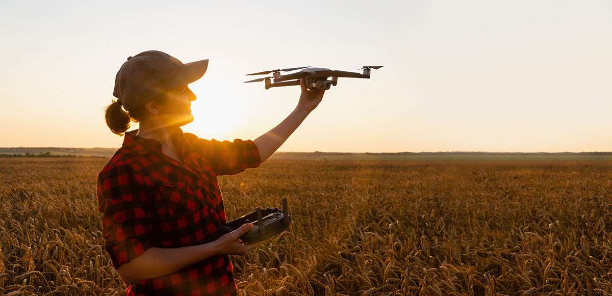 Woman farmer with drone on a wheat field