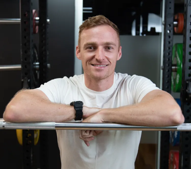 Man with crossed arms in white t-shirt.