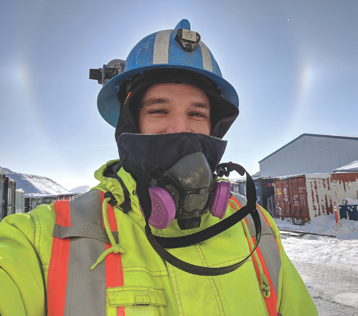 Person in hi-vis jacket wearing helmet and face mask