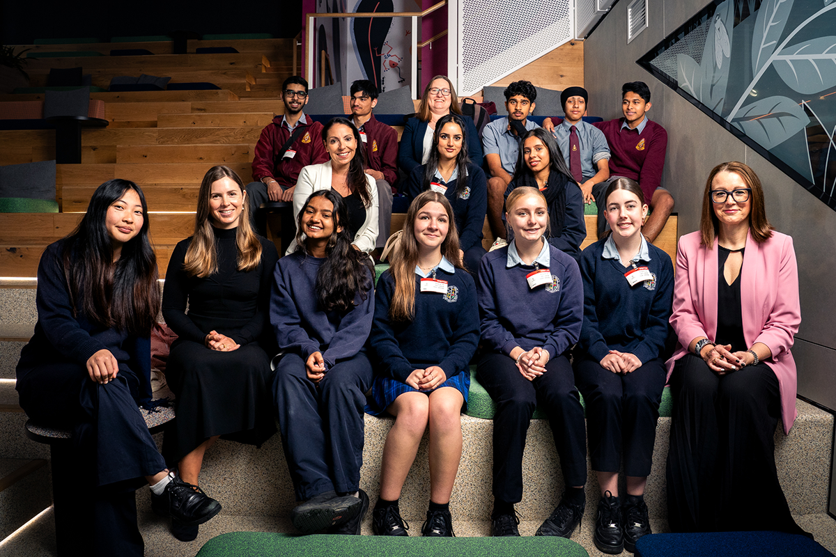 Students and adults sitting on stairs