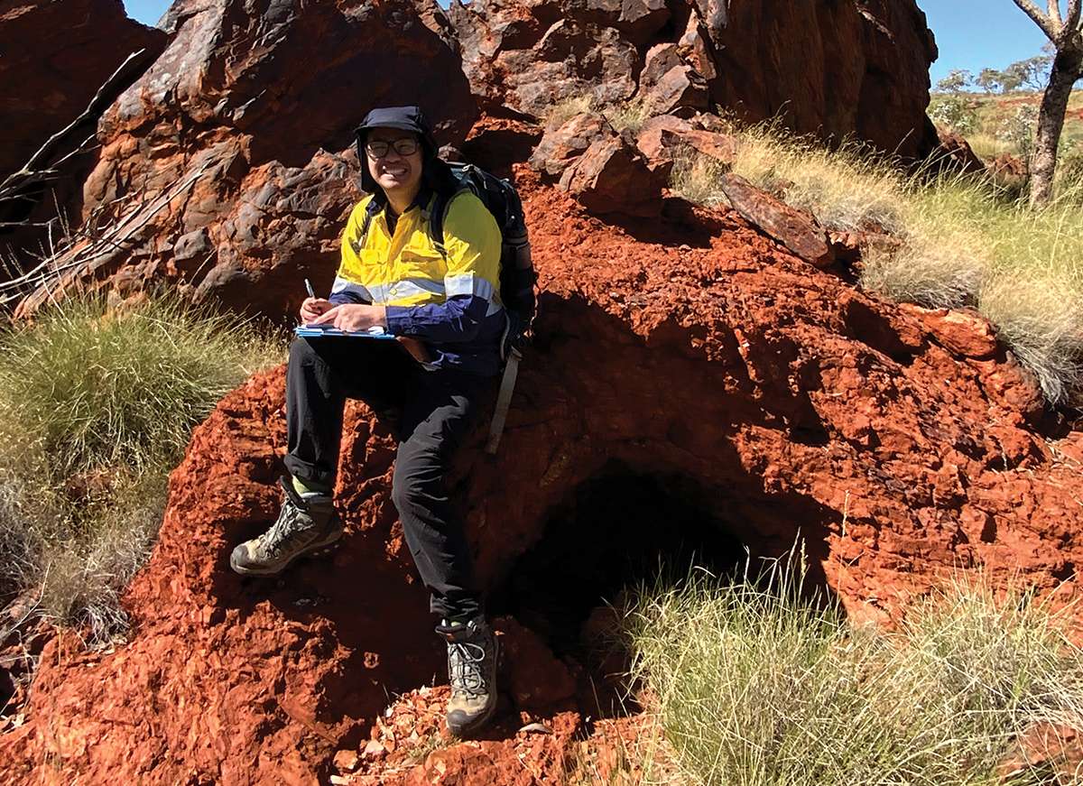 Man in high vis sitting on a red rock
