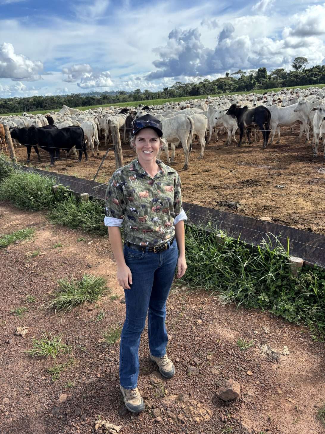 Woman at a farm standing next to cows