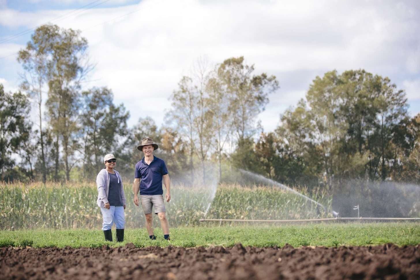 Two people standing in a field of crops