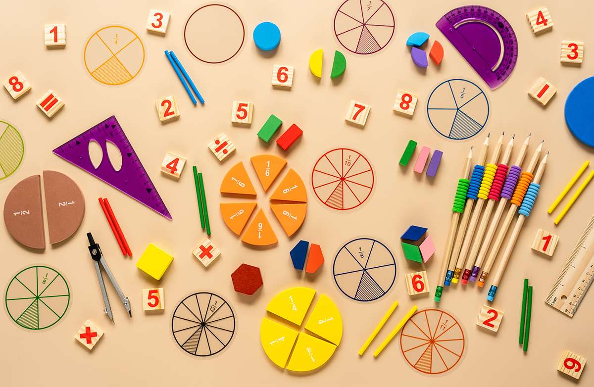 Wooden toy blocks. School supplies, math fractions, pencils, numbers, on beige background. Back to school, education concept background.