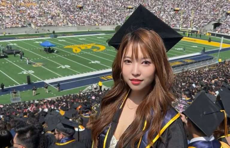 Woman in graduation gown and cap at American football