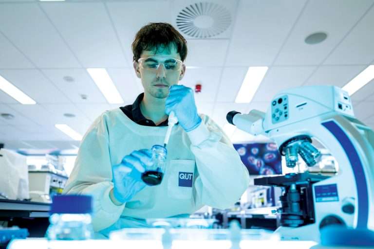 Man in lab with a pipette, blue glow