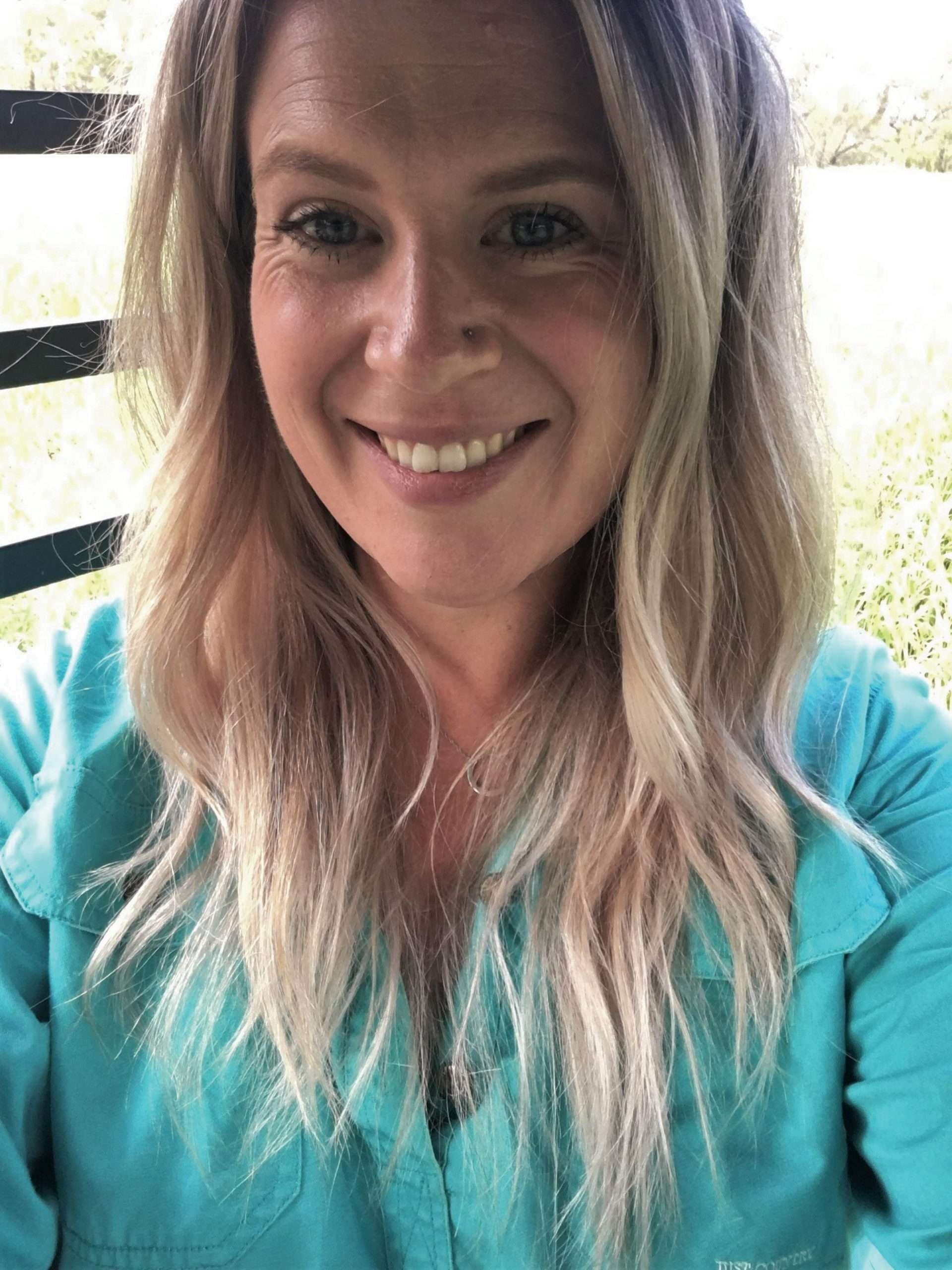 Person with long blonde hair looking at camera