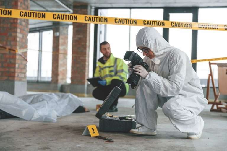 Man in white outfit taking photo of evidence