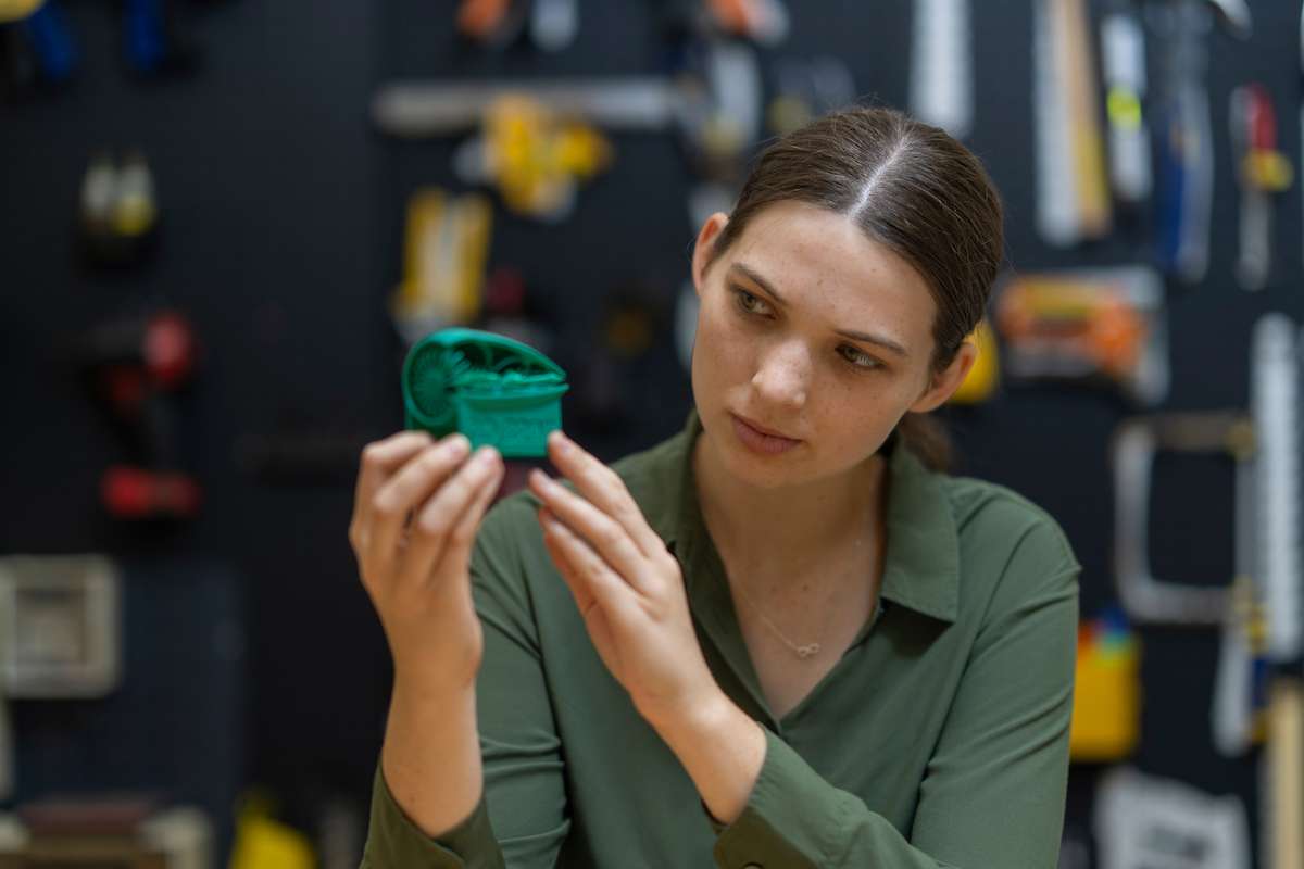Engineering student holding green item
