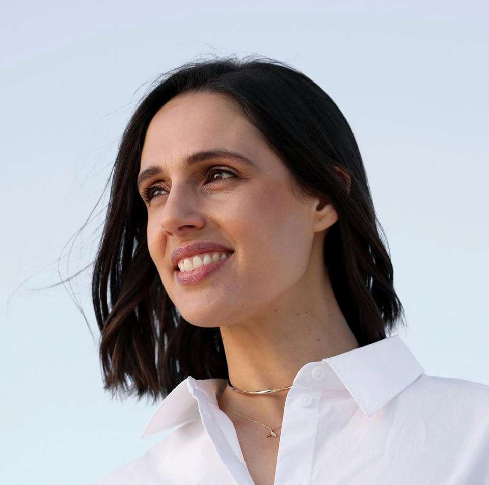 Woman with black hair wearing white shirt