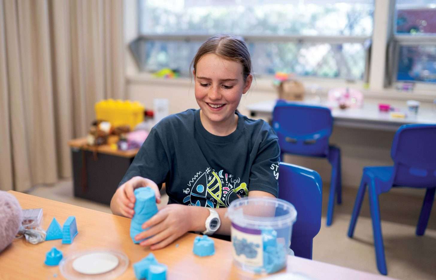 Girl moulding blue clay