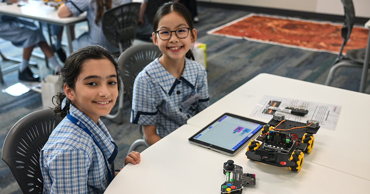 Two girls with a robot and ipad