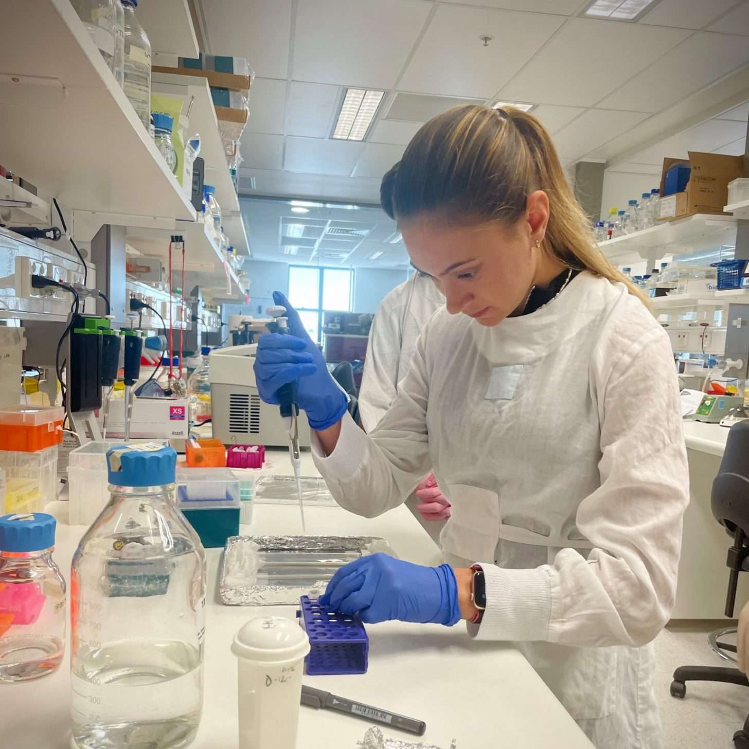 Woman in a lab using a pipette