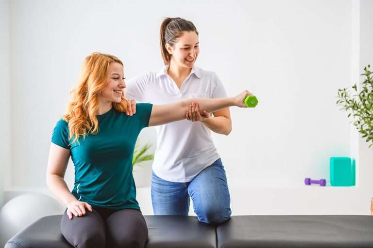 A Modern rehabilitation physiotherapy at work with client holding dumbbell