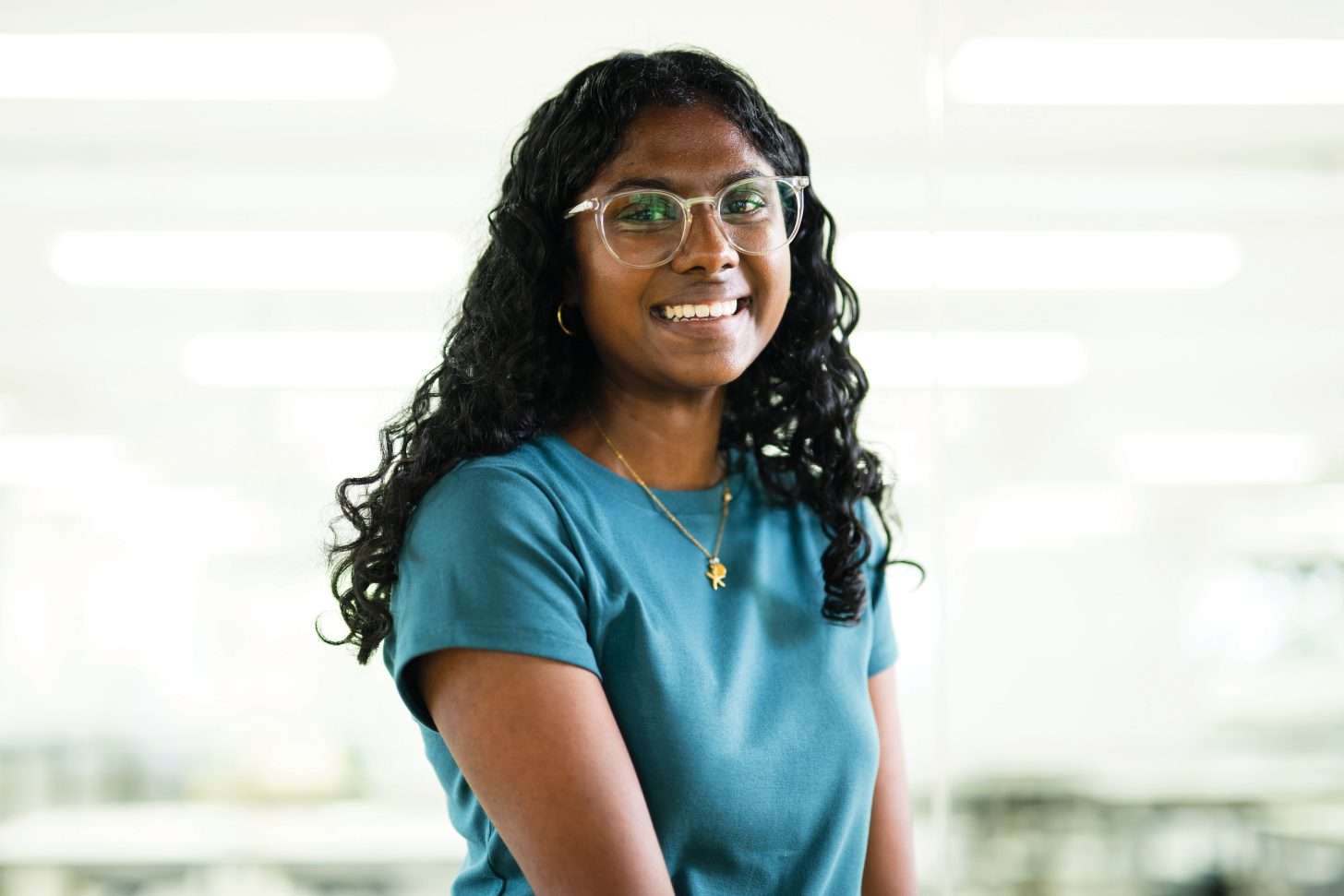 Woman with curly black hair and turquoise tee