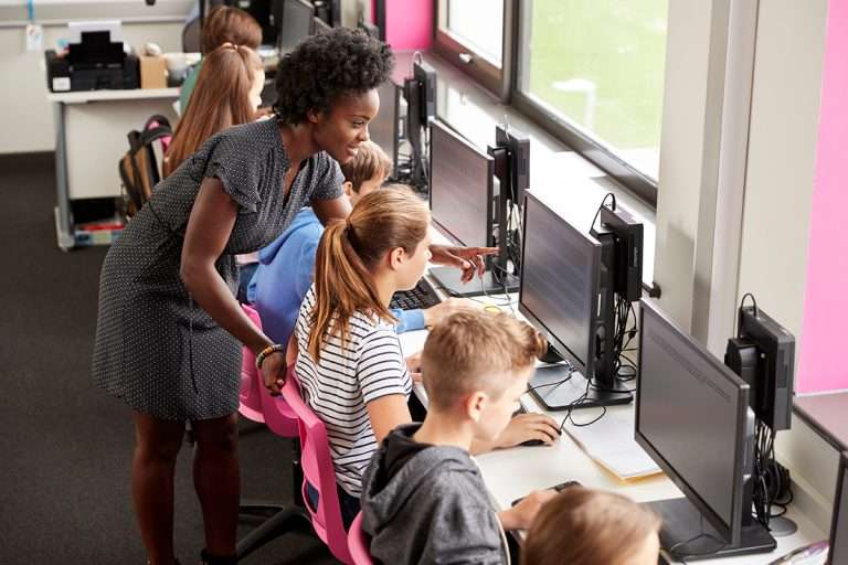 Teacher Helping Female,Pupil,Line,Of,High,School,Students,Working